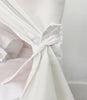 Close-up of a white fabric with a knot on a light gray background