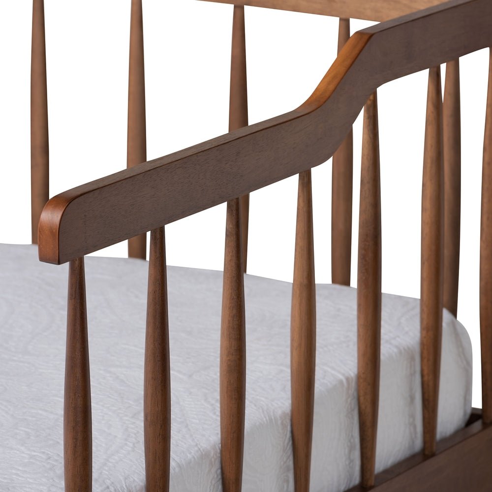 Wooden crib with white mattress on a white background
