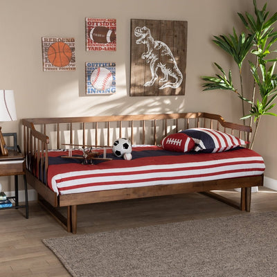 Wooden bed with red and white striped bedding in a room with sports-themed wall art.