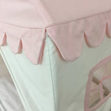Close-up of a pink scalloped bed skirt on a bed with white bedding.