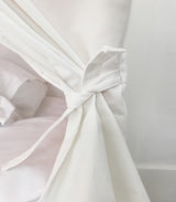Close-up of a white fabric with a knot on a light gray background