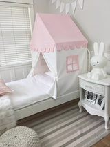 Children's bedroom with a pink play tent, white nightstand, and stuffed rabbit toy.