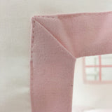 Close-up of a pink fabric corner with a blurred background