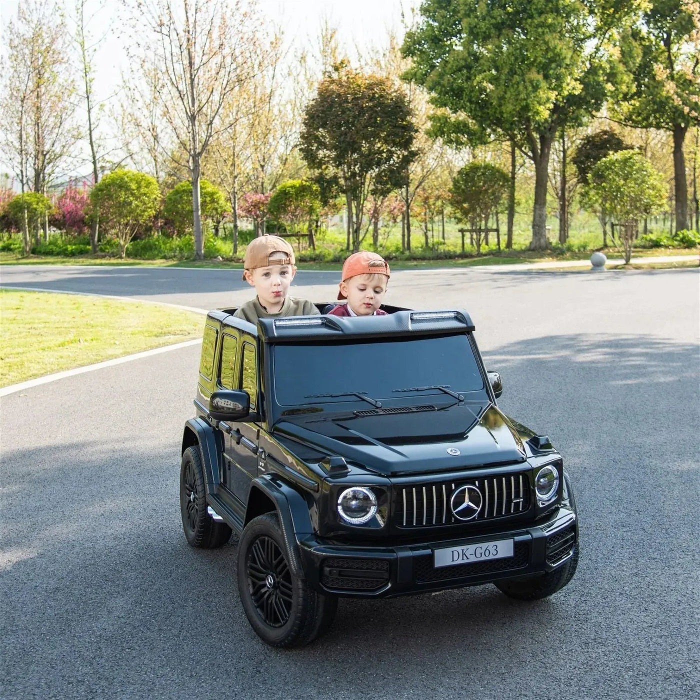 24V black Mercedes Benz G63 AMG 4x4 ride-on car for kids, featuring a realistic luxury SUV design, two seats, LED lights, working doors, and all-terrain wheels.