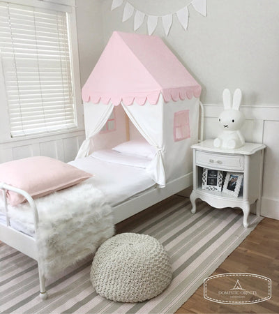 Pink and white children's bed canopy with scalloped edge in a bedroom setting.